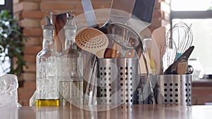 kitchen table.metal stands with cutlery,glass bottles with olive oil and vinegar