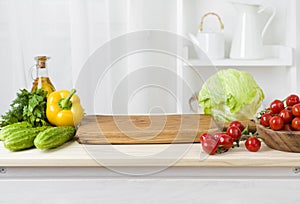Kitchen table with vegetables and cutting board for preparing salad