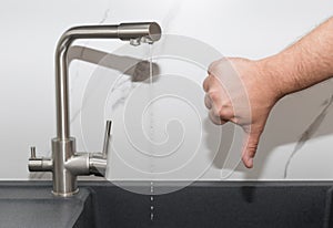 Kitchen tap with bad pressure flowing water. water shortage