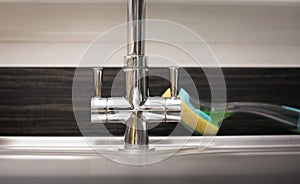 Kitchen tap isolated on bright background. Water saving solutions