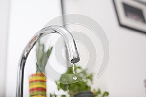 Kitchen tap isolated on bright background. Water saving solutions