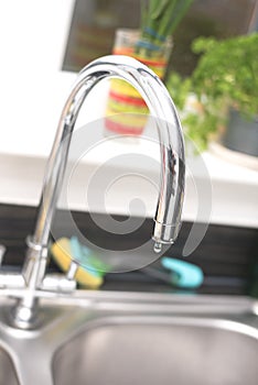 Kitchen tap isolated on bright background. Water saving solutions