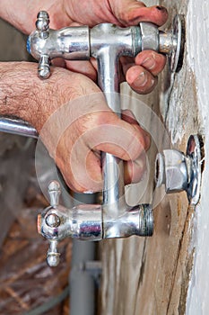 Kitchen tap repair, plumber hands holding bridge faucet closeup