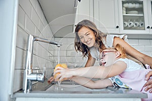 Kitchen tap, vegetables and mom with child washing yellow pepper, growth and development in happy home. Love, smile and