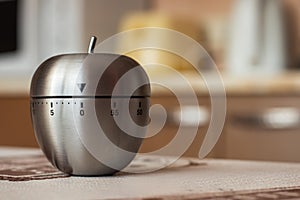 Kitchen timer in shape of apple on table. Space for text