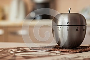 Kitchen timer in shape of apple on table. Space for text