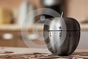 Kitchen timer in shape of apple on table. Space for text