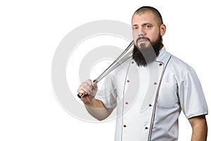 Kitchen tools concept. Cook with serious face holding whisk on the shoulder. Chef with whipping utensil. Man or hipster with beard