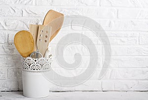 Kitchen tools, olive cutting board on a kitchen shelf against a white brick wall. selective focus