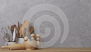 Kitchen tools, utensils and kitchenware on the table on a grey concrete background.