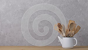 Kitchen tools, utensils and kitchenware on the table on a grey concrete background.