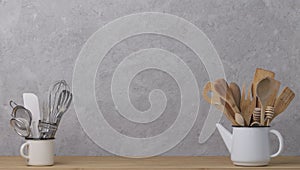 Kitchen tools, utensils and kitchenware on the table on a grey concrete background.