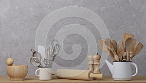 Kitchen tools, utensils and kitchenware on the table on a grey concrete background.