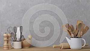 Kitchen tools, utensils and kitchenware on the table on a grey concrete background.