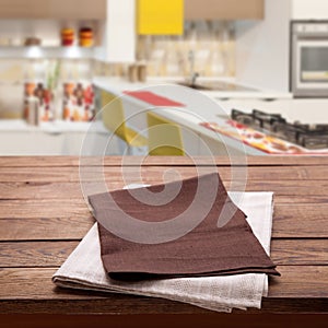 Kitchen towel on empty wooden table. Napkin close up top view mock up for design. Kitchen rustic background.