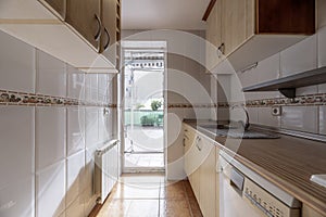 Kitchen in a tube-type room with cabinets on both sides and access to a large terrace