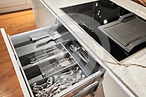 Kitchen utensil cutlery drawer organizer tray with simple set of tools, minimalist order. Open drawer with different