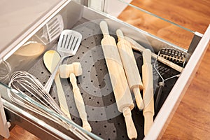 Kitchen utensil cutlery drawer organizer tray with simple set of tools, minimalist order. Open drawer with different