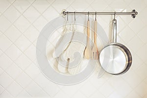 Kitchen utensil Glove and Pan Wooden Spoon on Tiles wall