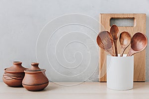 Kitchen utensils background. Wooden spoons and cutting board on light background with copy space