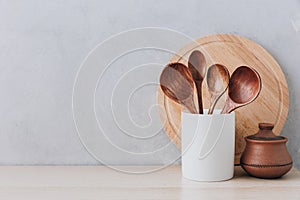 Kitchen utensils background. Wooden spoons and cutting board on light background with copy space