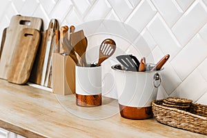 Kitchen utensils for cooking are on the countertop in the kitchen. saucepan, wooden cutting boards, knives.