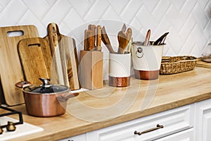 Kitchen utensils for cooking are on the countertop in the kitchen. saucepan, wooden cutting boards, knives