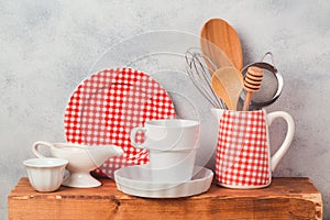 Kitchen utensils and dishware on wooden board