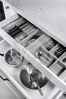Kitchen utensils in drawer. Forks, spoons and knives.
