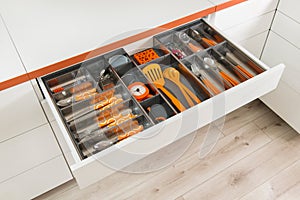 Kitchen utensils in drawer. Forks, spoons and knives.