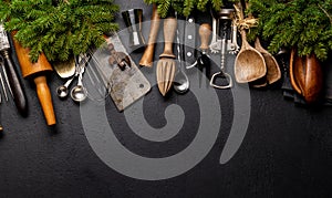 Kitchen utensils and fir tree branches on cooking table. Christmas cooking concept