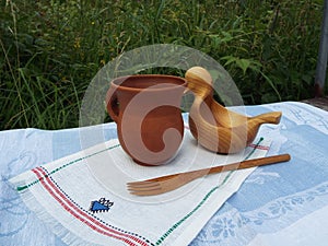 Kitchen utensils made of wood and clay handmade on the background of nature.