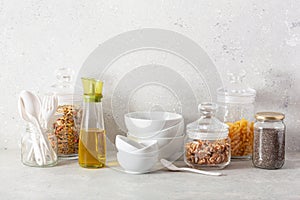 Kitchen utensils on modern simple counter, kitchenware jars with dry ingredients bowls