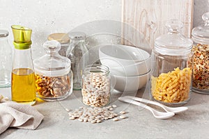 Kitchen utensils on modern simple counter, kitchenware jars with dry ingredients bowls