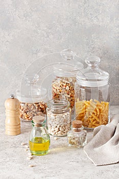 Kitchen utensils on modern simple counter, kitchenware jars with dry ingredients bowls