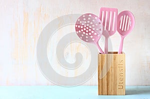 Kitchen utensils over wooden textured background