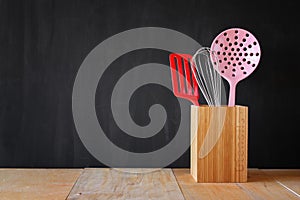 Kitchen utensils over wooden textured background