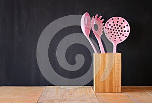 Kitchen utensils over wooden textured background