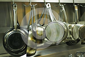 Kitchen utensils, pans and pots hanging with hooks