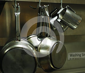 Kitchen utensils, pans and pots hanging with hooks