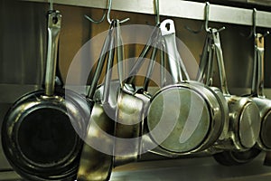 Kitchen utensils, pans and pots hanging with hooks