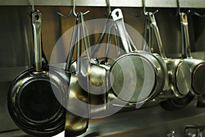 Kitchen utensils, pans and pots hanging with hooks