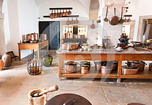 Kitchen utensils in retro style. Interior of an big old house with vintage table, traditional cooper pots for cooking