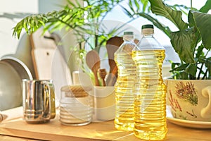 Kitchen utensils, sunflower oil on wooden table in pantry