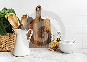 Kitchen utensils, tools and dishware on on the background white tile wall