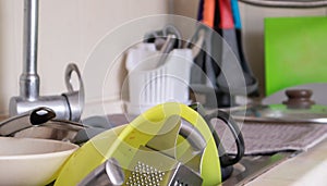 The kitchen utensils in the wash basin need to be washed. A pile of dirty dishes in the kitchen sink. Kitchen utensils need