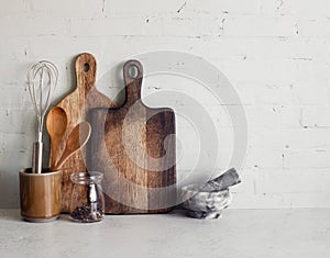 Kitchen utensils-wooden spoons and cutting boards on stone table