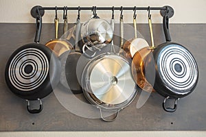 Kitchen wall rack for hanging pots, pans, aprons, and other utensils for storage and decor photo