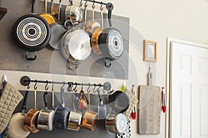 Kitchen wall rack for hanging pots, pans, aprons, and other utensils for storage and decor