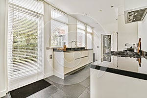 a kitchen with white cabinets and a large window